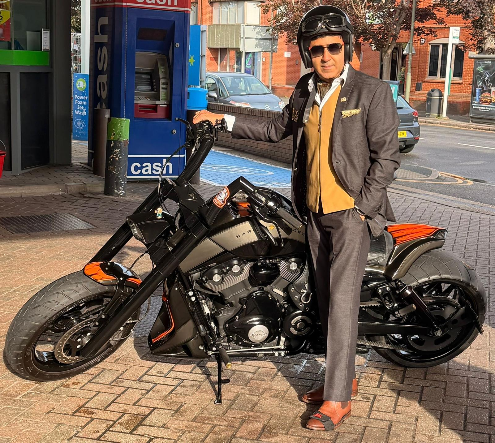 Rider in a suit beside a Harley-Davidson V-Rod