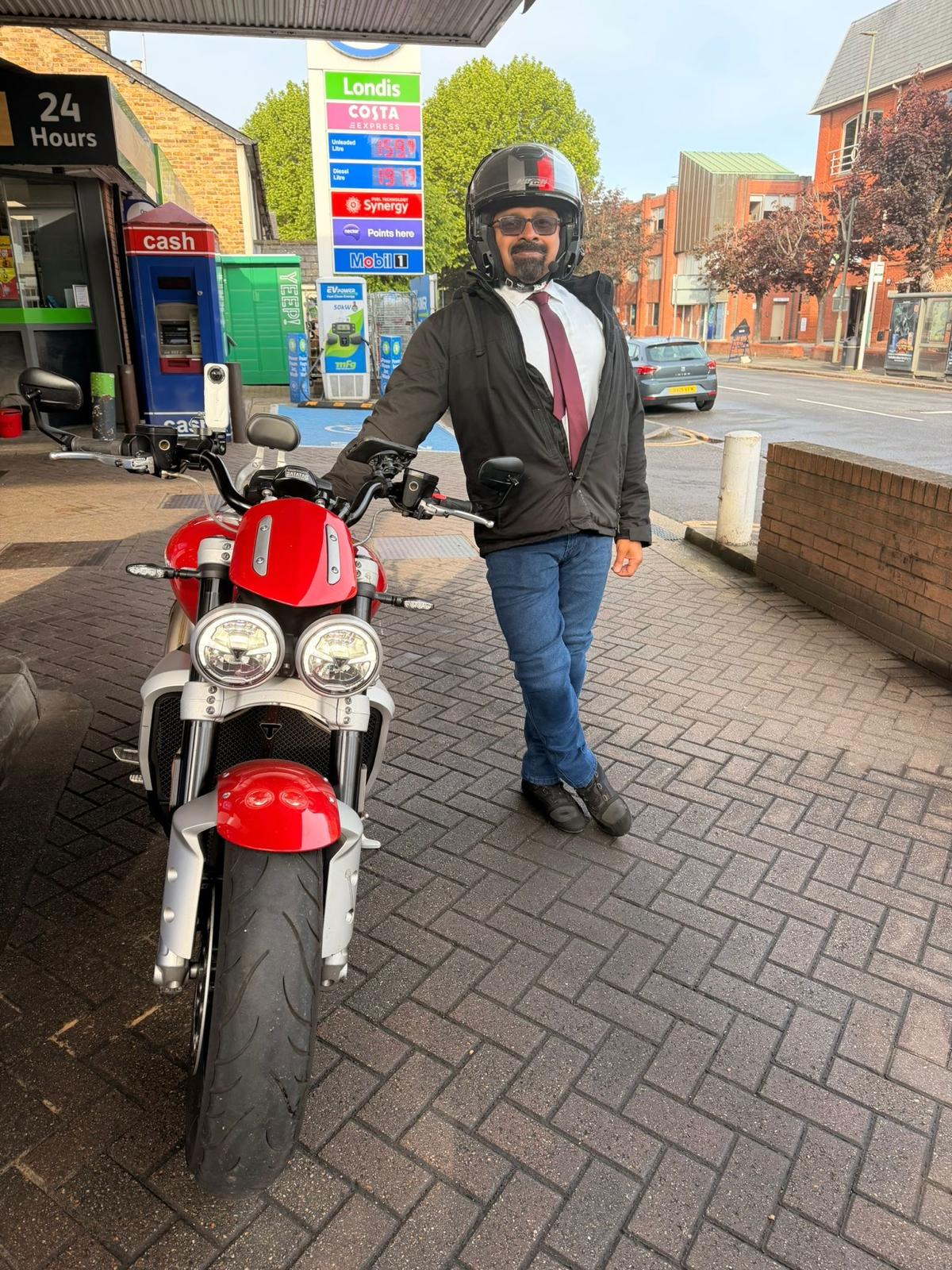 Rider with a Triumph Speed Triple at the fuel stop